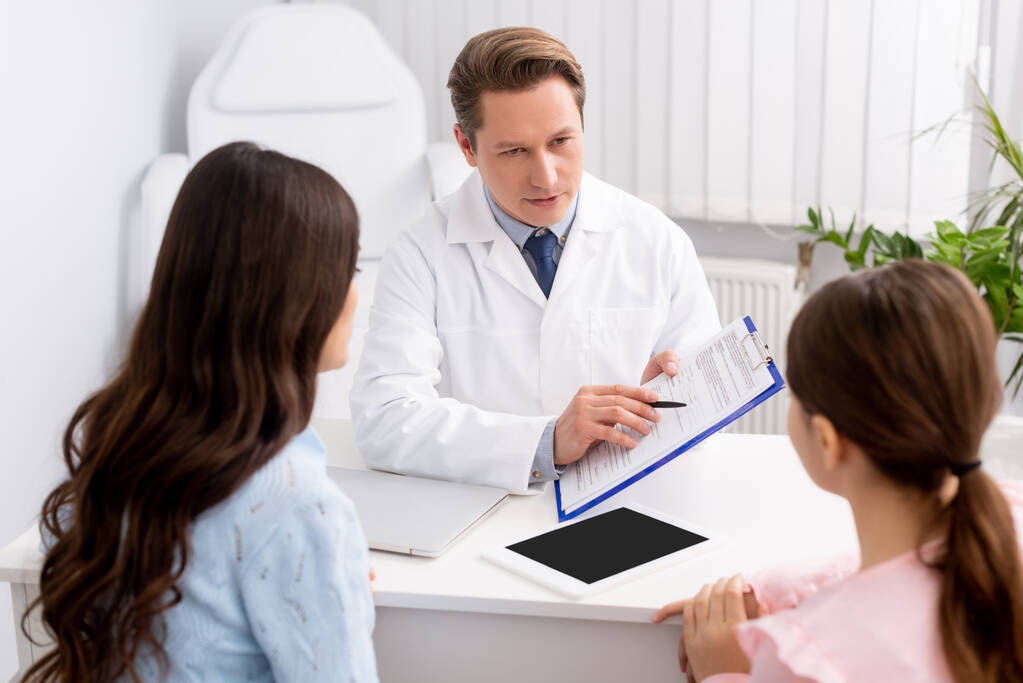 Pediatrician reviewing a chart with a family